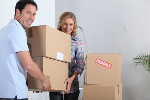 Local man with van in Raynespark handling packed moving boxes